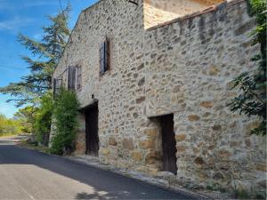 een oud stenen gebouw met twee deuren in een straat bij La Roche 8 in Aigues-Vives
