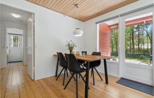a dining room with a wooden table and chairs at Nice Home In Aakirkeby With Wifi in Vester Sømarken