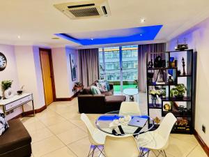 a living room with a glass table and white chairs at Two-Bedroom Durban Point Waterfront Penthouse in Durban