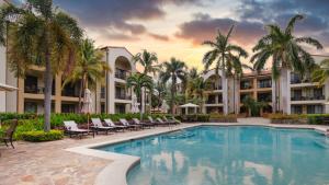 科克1-Bedroom Near Pool的一个带椅子和棕榈树的度假村游泳池