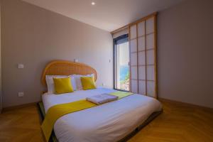 una camera da letto con un letto grande con una grande finestra di Villa d'expection, 10 personnes avec piscine intérieure a La Combe-de-Lancey Altre 39 foto