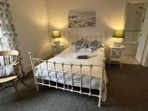 a bedroom with a white bed with two lamps at Lord Nelson Hotel in Bridport