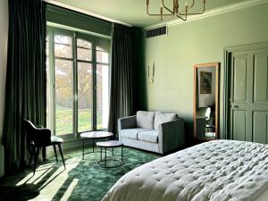 a bedroom with a bed and a couch and a window at Les Hayes en Sologne - Proche Chambord in Fontaines-en-Sologne