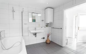 a white bathroom with a sink and a bath tub at Ostseebad-Zinnowitz-Charmantes-Ferienappartement-Morgensonne in Zinnowitz +15 photos