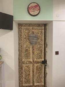 Una porta in una stanza con un orologio sul muro di Studette Le figuier a Perpignano
