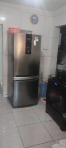 Una cocina con refrigerador de acero inoxidable y estufa. en Casa LF, en Salvador