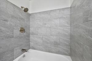 a bathroom with a white tub and a gray wall at Spacious Alpharetta 3bedroom Home in Alpharetta +14 photos
