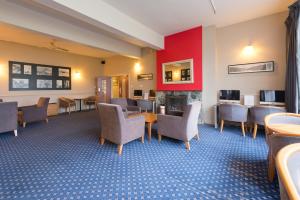 Heartland Hotel Fox Glacier في فوكس جلاسييه: غرفة انتظار مع كراسي ومدفأة