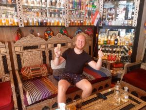 a man sitting on a bed in a bar at Hurghada Sea View Apartment in Hurghada