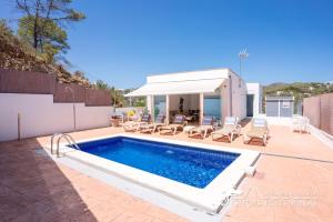 a swimming pool with lounge chairs and a swimming poolvisor at Villa Senia, close to Sitges with private pool in Olivella