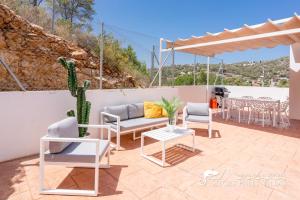 a patio with chairs and a table and a cactus at Villa Senia, close to Sitges with private pool in Olivella