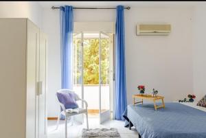 une chambre avec un lit, une chaise et une fenêtre dans l'établissement "Stella Home " Perfetto per le tue vacanze in Sicilia sul Golfo di Castellammare ! Relax a pochi mt dal mare per Amici e Famiglie, à Alcamo Marina