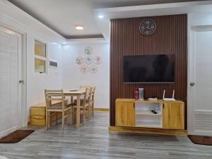 ein Esszimmer mit einem Tisch und einem Flachbildfernseher in der Unterkunft Casa Danico - 2 BR Spacious unit in Antipolo in Maagay + 4 Fotos