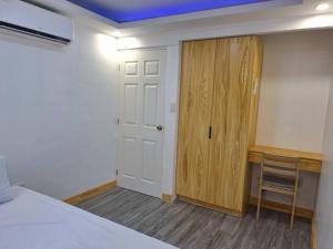 ein Schlafzimmer mit einem Bett, einer Tür und einem Schreibtisch in der Unterkunft Casa Danico - 2 BR Spacious unit in Antipolo in Maagay