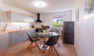 a kitchen with a table and chairs and a refrigerator at Bernsteinbad-Koserow-Haus-Fuenf-Elemente-Ferienwohnung-Erde in Ostseebad Koserow