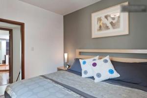 1 dormitorio con 1 cama con almohadas azules y blancas en Duplex Penthouse Zona Rosa en Ciudad de México