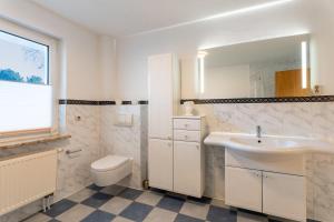 ein weißes Badezimmer mit Waschbecken und Toilette in der Unterkunft Bernsteinbad Koserow - Haus Fünf Elemente Ferienwohnung Feuer in Ostseebad Koserow + 18 Fotos