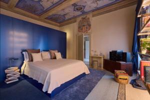 a bedroom with a large bed with a blue wall at Gironda in Ravenna