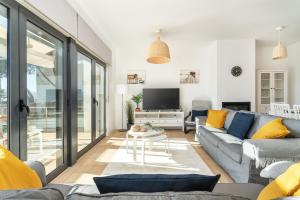 a living room with a couch and a tv at Host Wise - Serene Spacious House - Swimming Pool & Garden in Olhos de Água