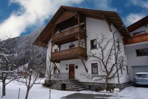 une maison avec un balcon au-dessus dans l'établissement Haus Ruetzbach, à Neustift im Stubaital