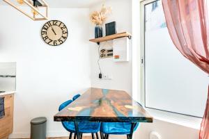 a table and chairs in a small room with a clock at Il Était Une Fois - GAP Chambre romantique & SPA in Gap