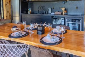 einen Holztisch mit Weingläsern und Essen darauf in der Unterkunft Cabana na Serra Lareira e Vista Deslumbrante in Rio Rufino