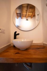 a white bowl sink on a wooden table with a mirror at Habitación Centro Histórico in Mompos
