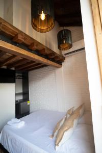 a bedroom with a white bed with two lights at Habitación Centro Histórico in Mompos