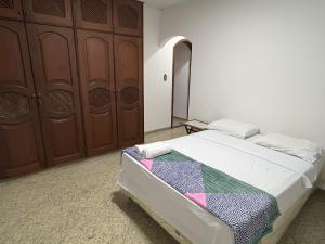 a bedroom with a bed and a wooden closet at Condomínio Bariloche in Salinópolis +11 photos