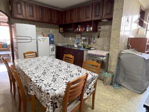 a kitchen with a table and chairs and a refrigerator at Condomínio Bariloche in Salinópolis