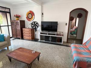 a living room with a television and a table at Condomínio Bariloche in Salinópolis
