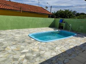 a swimming pool in a backyard with a green wall at Casa DIMAS in São Pedro