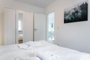 une chambre blanche avec un lit et un tableau au mur dans l'établissement Ostseebad-Zinnowitz-Ferienwohnung-Traum, à Zinnowitz