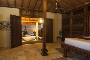 a bedroom with a bed and a tub in a room at Oceanfront Citakara Sari Villas in Candidasa +39 photos