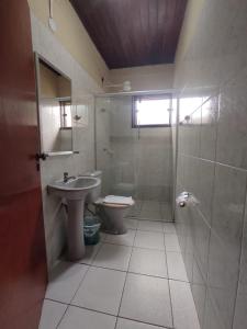 a bathroom with a toilet and a sink and a shower at Pousada Flor de Jambo in Ubatuba +7 photos