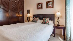 a bedroom with a large white bed with two lamps at 2-Bedroom, 2-Bath Condo Near Beach in Coco