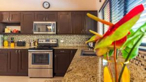 a kitchen with wooden cabinets and a counter top at 2-Bedroom, 2-Bath Condo Near Beach in Coco