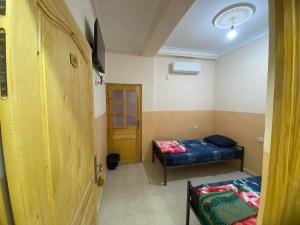 a small room with two beds and a window at Mirana Mayotte Hostel 47 in Ghardaïa