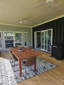 a dining room with a wooden table and chairs at Ardi Escape 2 Bedroom FREE WIFI in Arorangi