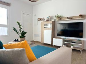 a living room with a couch and a television at El Paraiso in Gran Tarajal