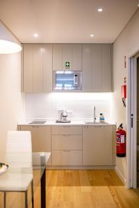 Una cocina con gabinetes blancos y un fregadero. en ISABELLA STUDIOS FUNCHAL, en Funchal