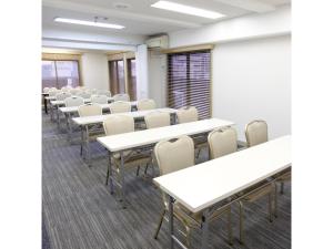 横浜市にあるYokohama Heiwa Plaza Hotel - Vacation STAY 36411vの白いテーブルと椅子が置かれた空き教室