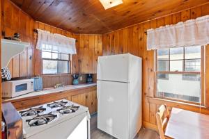 a kitchen with a stove and a white refrigerator at Loon Lodge in Holderness