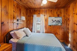 a bedroom with a bed in a wooden room at Loon Lodge in Holderness