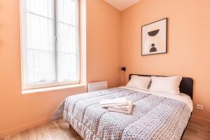 a bedroom with a bed with two towels on it at Confort et Espace 12pers centre Lamartine in Clermont-Ferrand