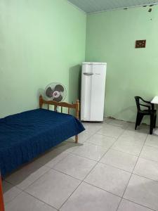 a bedroom with a bed and a refrigerator at Apartamentos Pura Vida em Atlântida Sul in Xangri-lá