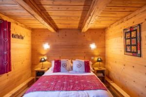 a bedroom with a bed in a log cabin at Les Chalets du Bonheur in Les Houches