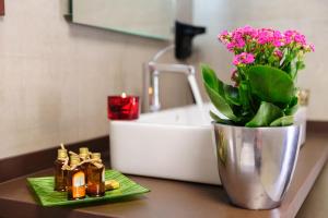 a bathroom counter with a sink and a vase with flowers at Suites Finca Los Olivos in Alcalá del Júcar