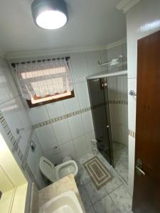 a bathroom with a toilet and a window and a shower at Acesso a tudo no centro e 6min a pé do mar in Capão da Canoa +13 photos