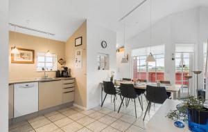 Una cocina y un comedor con mesa y sillas. en Holiday Home Anker Eskildsensvej Hvide Sande Vi, en Nørre Lyngvig